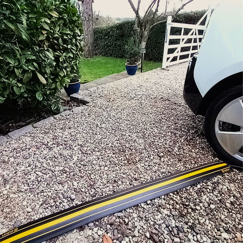 EV charging cable cover across a gravel path