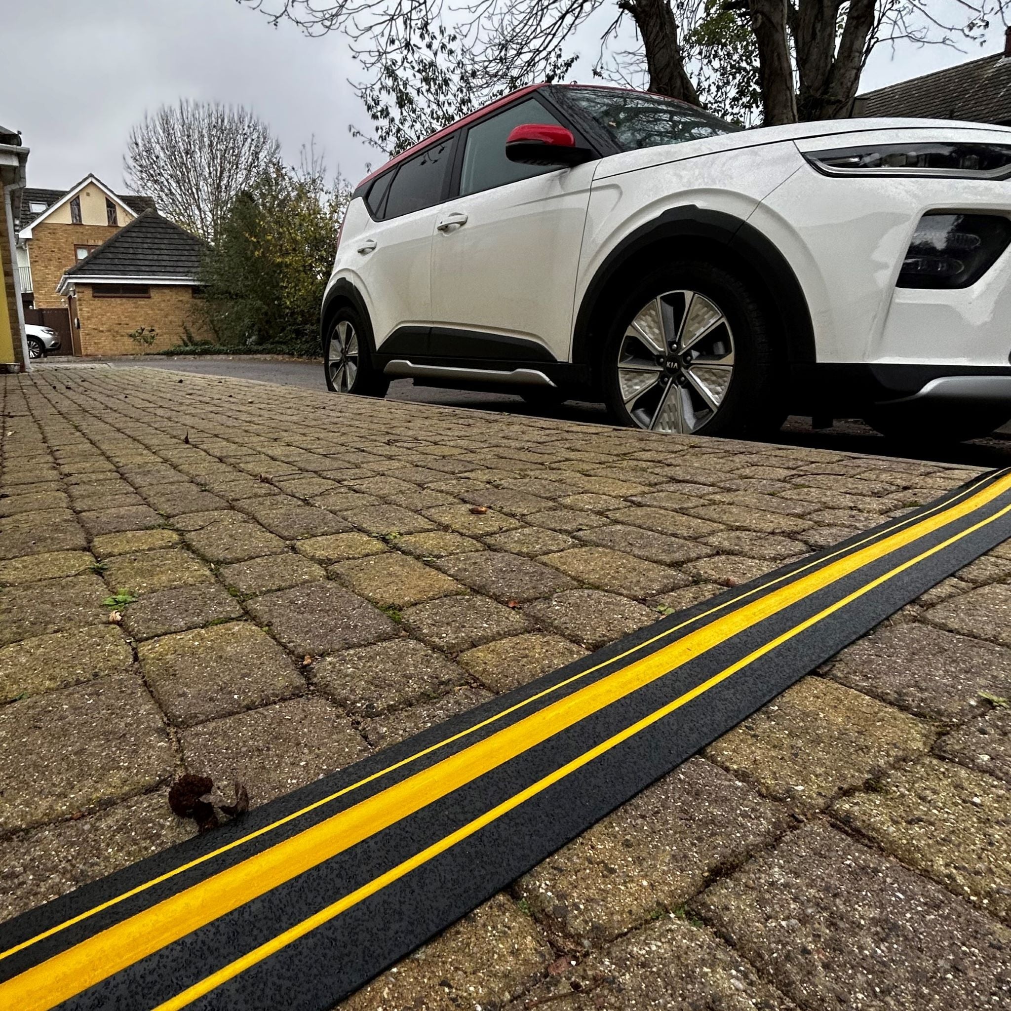 EV charger cable with cable protector across pavement